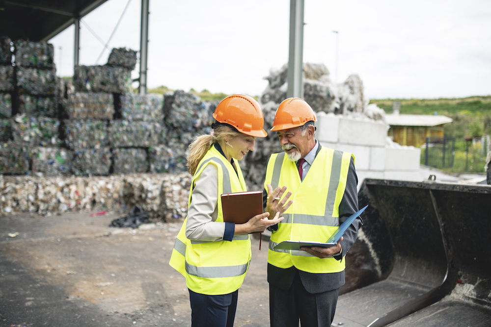 Waste management specialists planning at a recycling facility